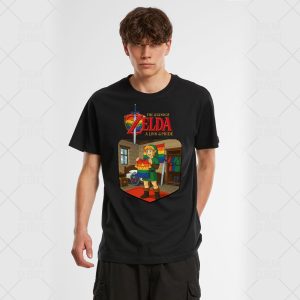 Un jeune homme aux cheveux bruns ondulés porte un T-shirt noir représentant Link de The Legend of Zelda tenant un drapeau arc-en-ciel de la fierté, avec le texte "The Legend of Zelda : A Link to Pride" au-dessus - parfait pour tout fan LGBTQIA+.