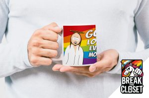Une personne tient un mug représentant un Jésus de dessin animé sur fond d'arc-en-ciel, avec le texte "Dieu aime tout le monde", célébrant la fierté LGBT. Dans le coin, il y a un logo "Break the Closet" avec une licorne et un poing levé.