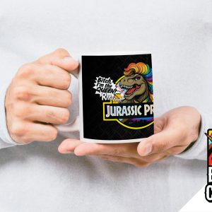 Une personne vêtue d'un pull léger tient une tasse sur laquelle figurent un T-Rex aux couleurs de l'arc-en-ciel, le texte Bitch, I'm the Queen Rarr ! et Jurassic Pride (fierté jurassique). Dans le coin, un logo "Break the Closet" avec une licorne arc-en-ciel célèbre la fierté LGBTQIA+.