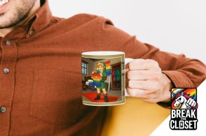 Une personne vêtue d'une chemise brune tient un mug illustré d'une personne portant un pull arc-en-ciel, entourée de drapeaux de la fierté. L'image met en évidence le logo "Break the Closet" avec une licorne et les couleurs de l'arc-en-ciel, célébrant ainsi la dynamique communauté LGBTQIA+.