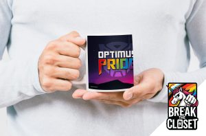 Une personne vêtue d'un pull léger tient un mug sur lequel figure le texte OPTIMUS PRIDE en lettres grasses et colorées. Dans le coin inférieur droit se trouve le logo BREAK THE CLOSET avec une licorne et un poing arc-en-ciel, célébrant la fierté LGBT.