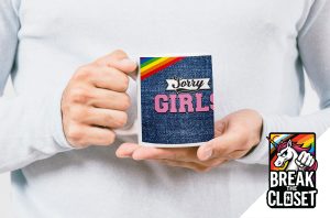 Une personne vêtue d'un pull blanc tient une tasse avec une bande arc-en-ciel, une texture en denim et le texte Sorry Girls (Désolées les filles), illustrant la fierté queer. En bas à droite se trouve le logo de la licorne Break the Closet, avec un poing levé et une crinière arc-en-ciel.