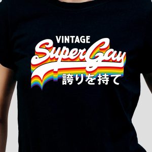 Une personne portant une chemise noire avec l'inscription "Vintage Super Gay" en gras et en rayures arc-en-ciel est fière de son style avec des caractères japonais en dessous - parfait pour montrer la fierté queer et LGBTQIA+.
