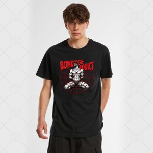 Un jeune homme homosexuel aux cheveux bruns ondulés porte le tee-shirt unisexe Bandage Addict, qui affiche un personnage de bande dessinée dans des cordes de bondage, "BANDAGE ADDICT" en lettres rouges grasses au-dessus, et un site web rouge en arrière-plan.