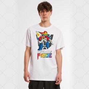 Un jeune homme porte un T-shirt blanc représentant un robot coloré tenant un drapeau de la fierté, avec le texte OPTIMUS PRIDE en lettres arc-en-ciel grasses - une façon amusante et dynamique de montrer la fierté LGBT.
