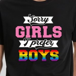 Une personne portant un T-shirt noir avec le texte Sorry GIRLS I prefer BOYS, affichant fièrement sa fierté LGBT. GIRLS est en rose, BOYS dans les couleurs de l'arc-en-ciel, et le reste du texte est en blanc - parfait pour exprimer son identité queer.
